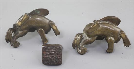 A pair of Chinese bronze mythical beast scroll weights and a similar seal, 18th/19th century, 6.5cm and 3cm